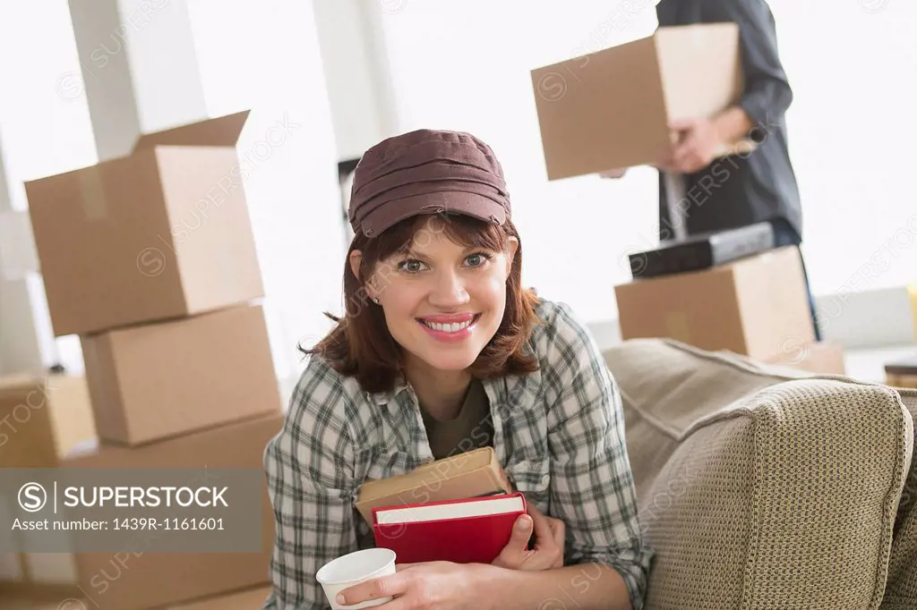Woman sitting with books whilst moving home