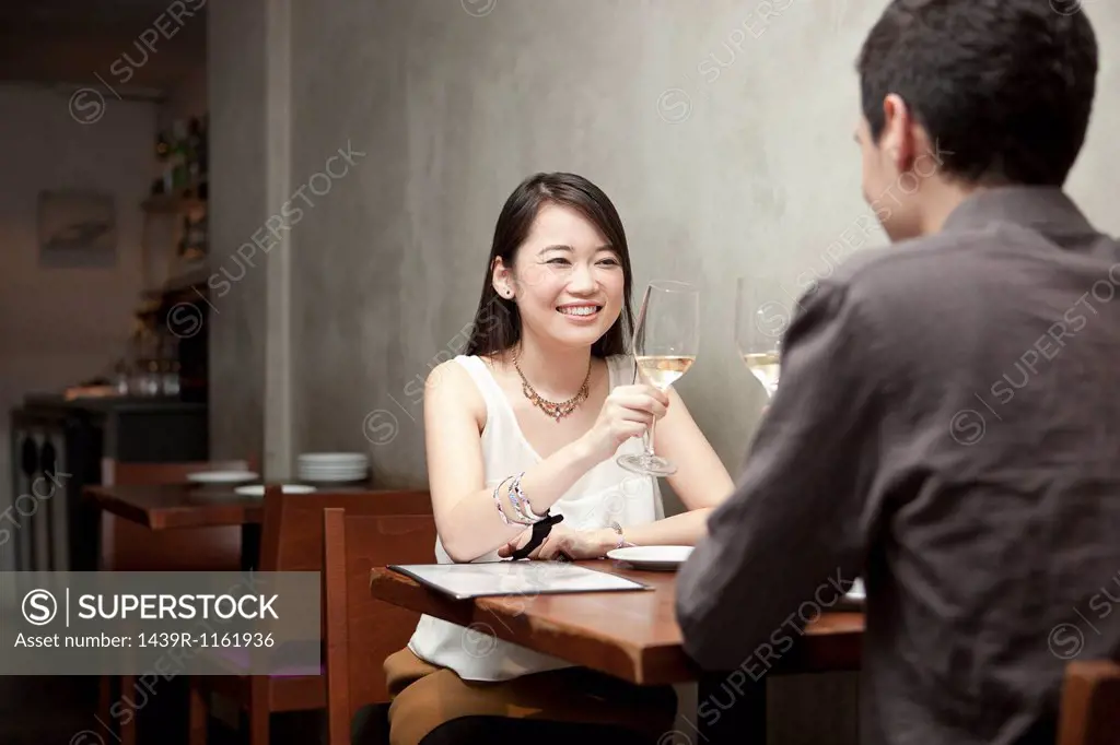 Young couple toasting white wine in restaurant