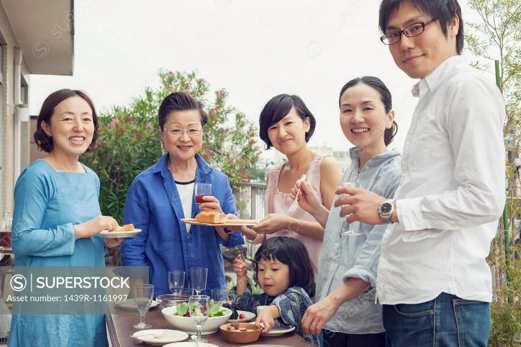 Three generation family eating outdoors, portrait