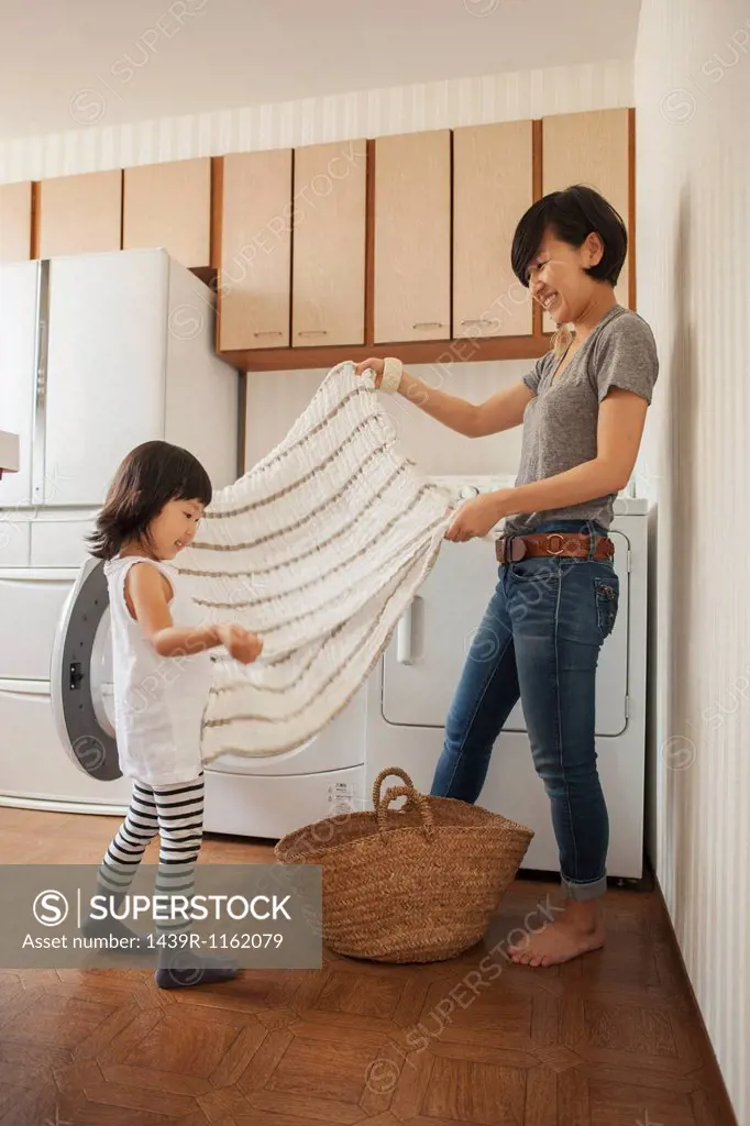 Mother and daughter folding towel