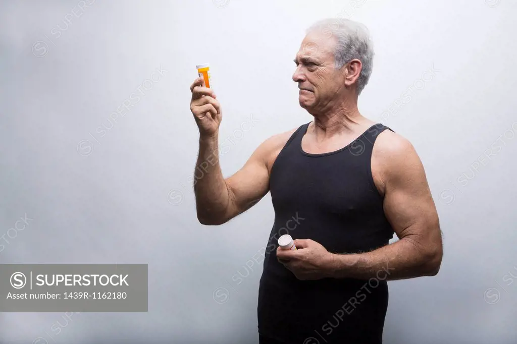 Senior man looking at pill bottles