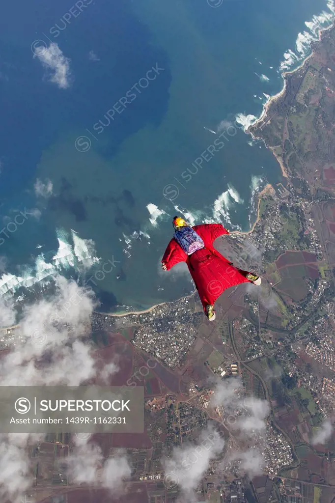Woman in wingsuit flying above Honolulu, Hawaii