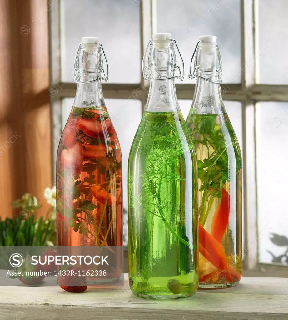 Three bottles of pickled herbs on windowsill