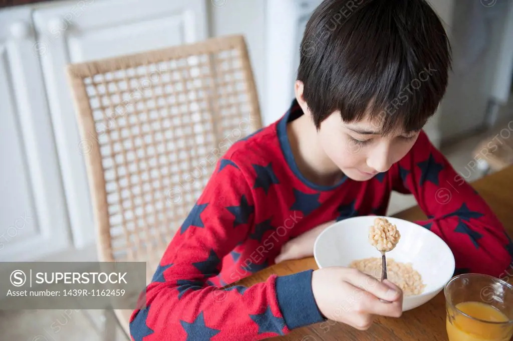 Boy eating breakfast cereal at table