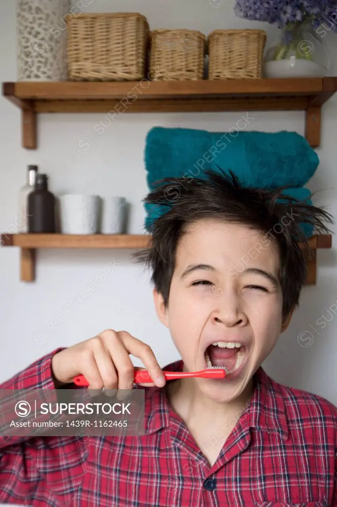 Boy yawning and brushing teeth, portrait