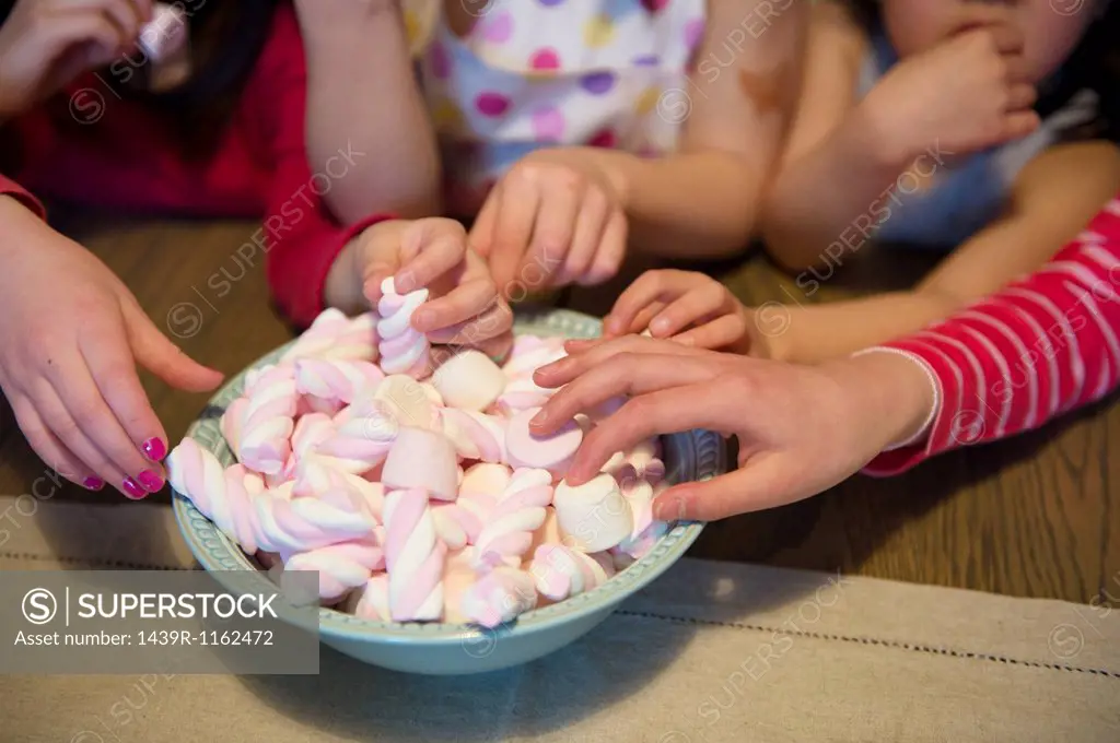 Girls reaching for sweets, close up