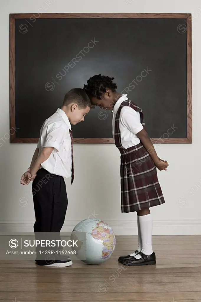 Boy and girl looking at globe