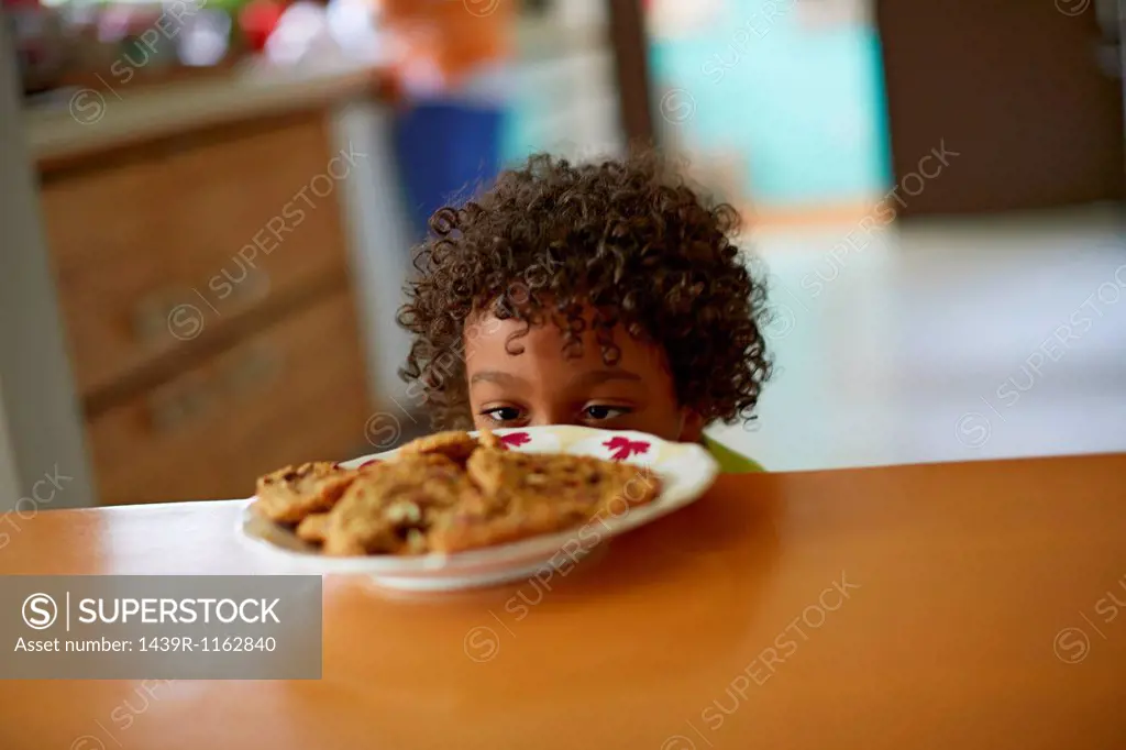 Boy looking at plate of cookies