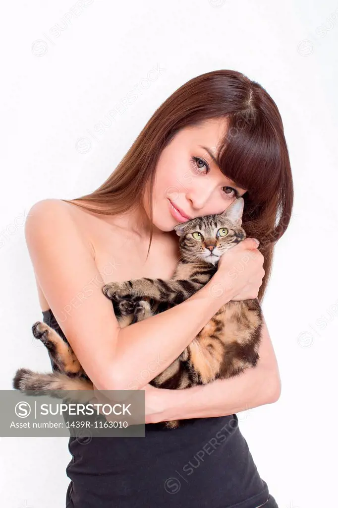 Portrait of woman holding tabby cat