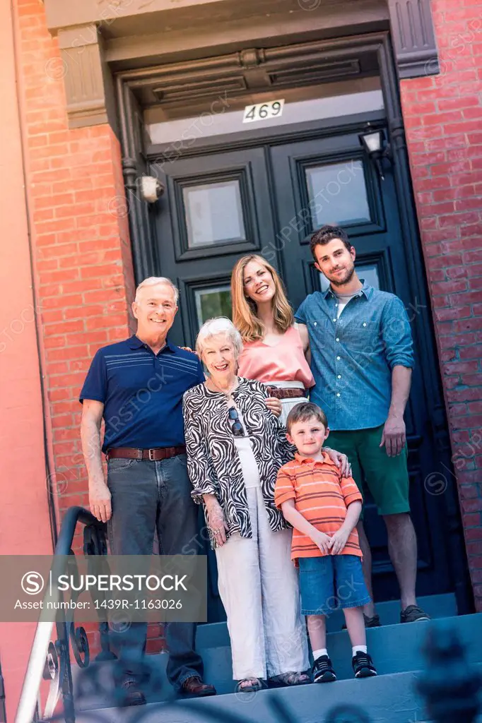 Portrait of three generation family outside front door