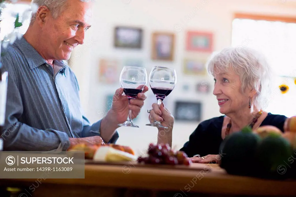 Senior couple toasting with red wine