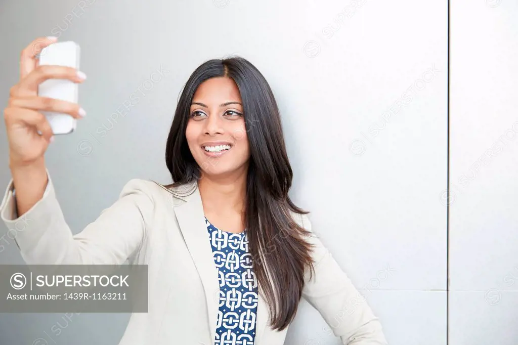 Woman taking self portrait using smartphone