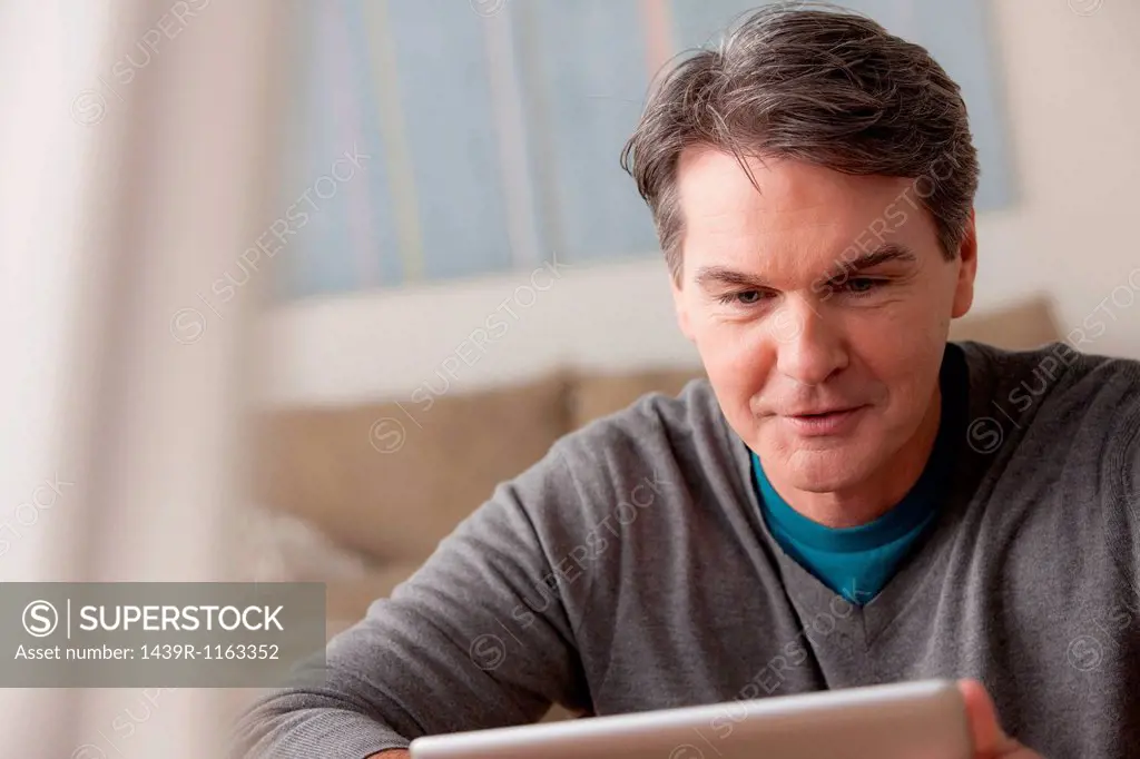 Mature man using digital tablet
