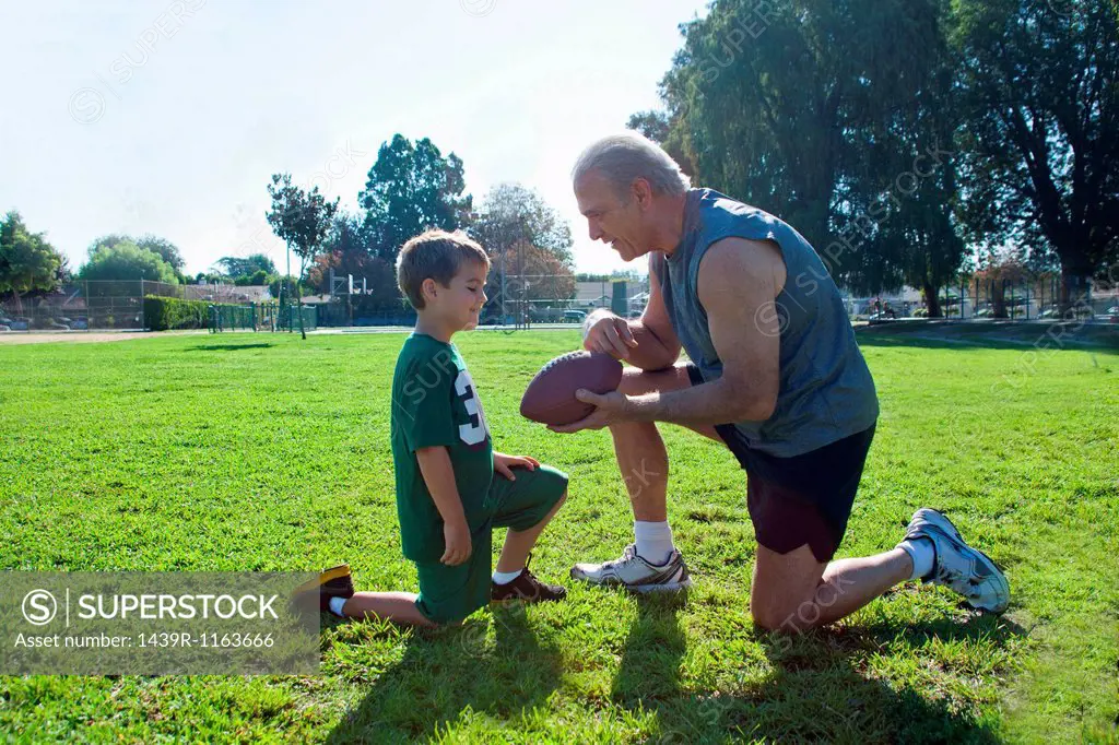 Boy and grandfather with american football