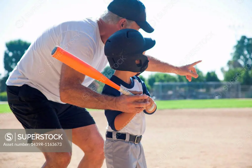 Man teaching grandson to play baseball