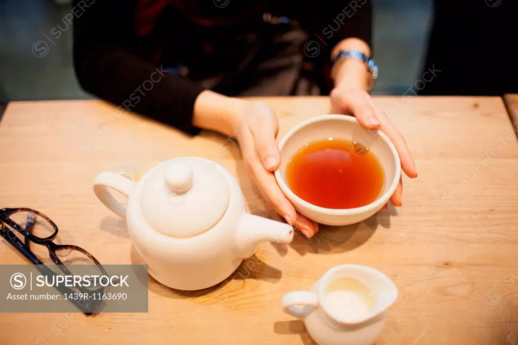 Woman holding cup of tea, high angle