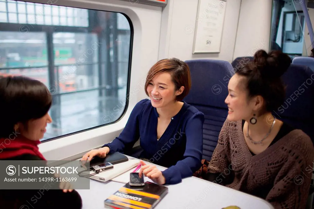 Young women talking on train