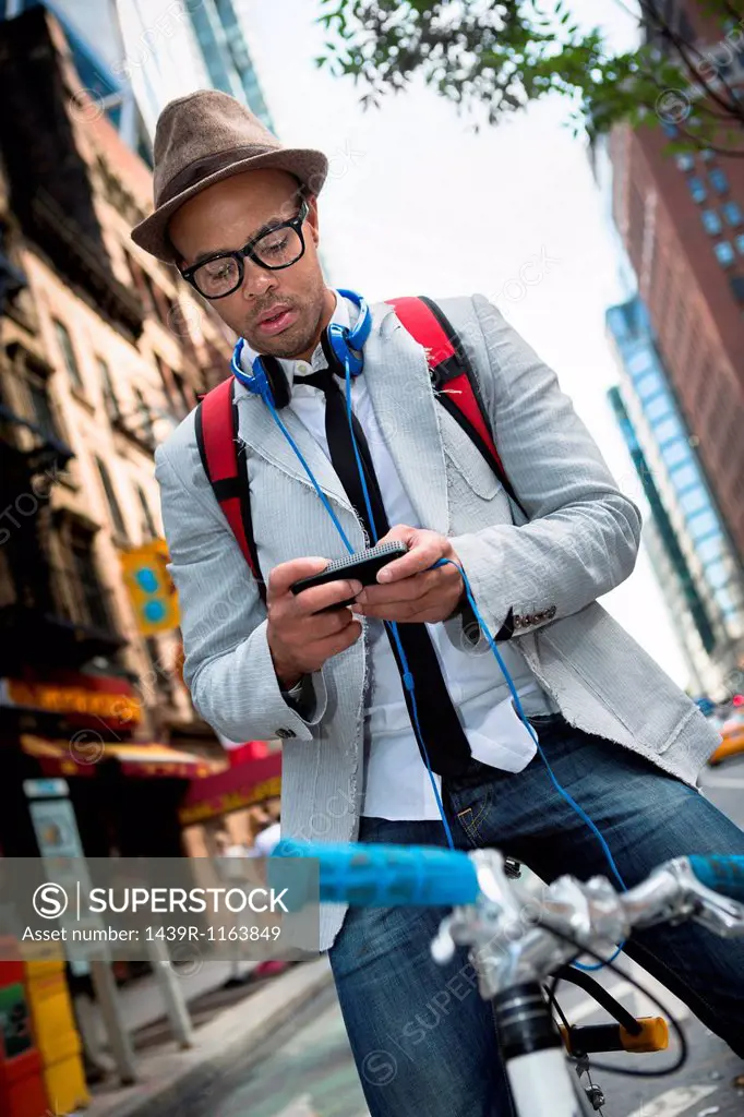 Young man on bike using smartphone