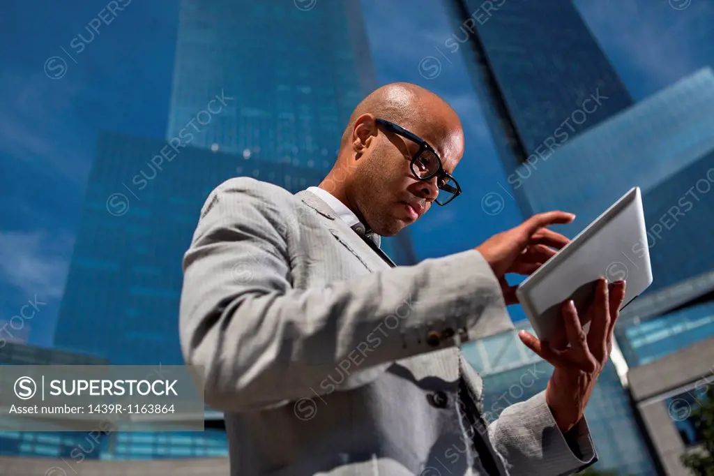 Young businessman using table outside office buildings