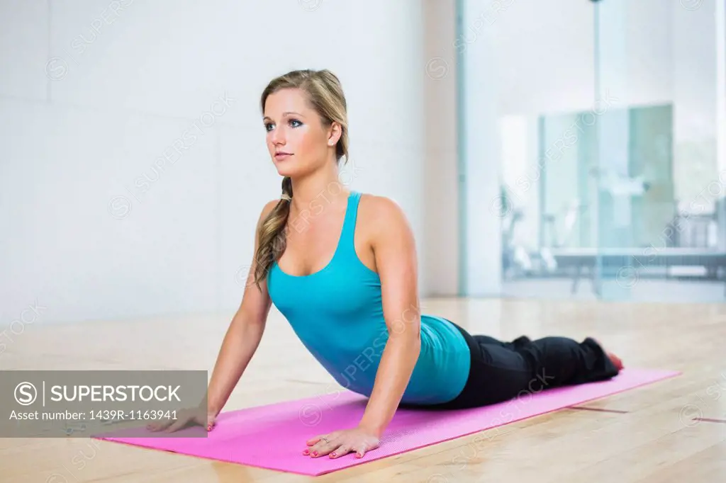 Young woman on mat in yoga position