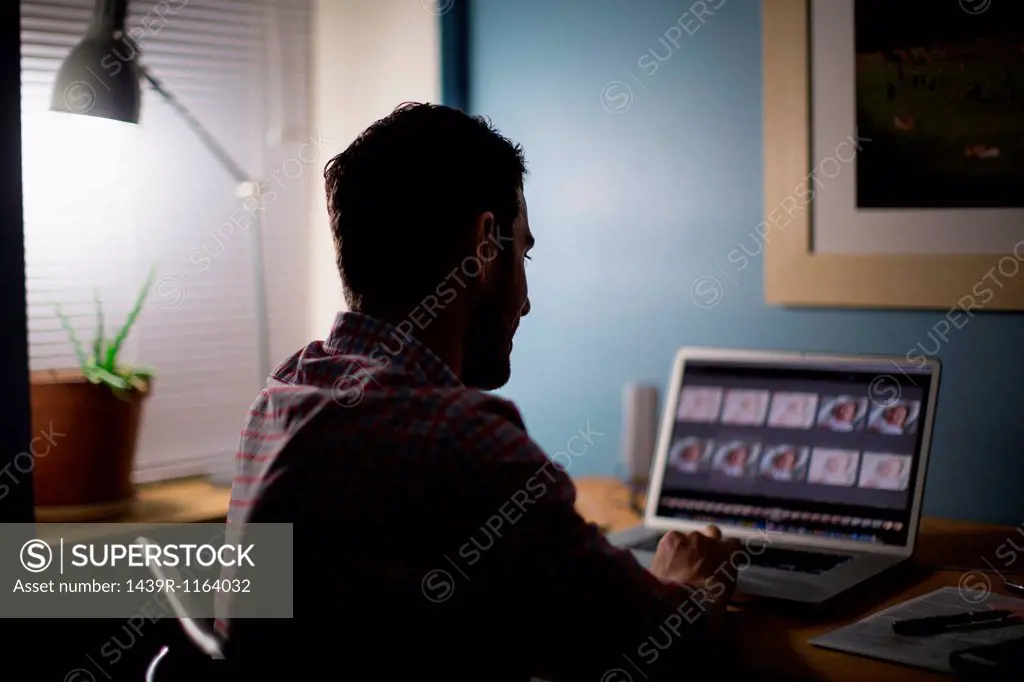Man sitting at desk using laptop