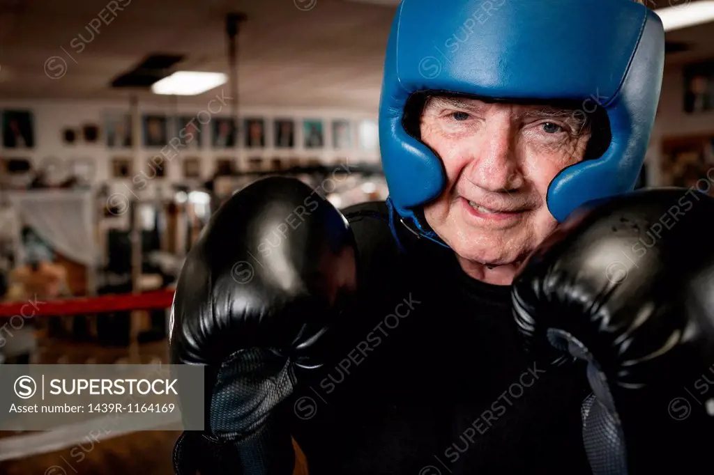Senior man wearing boxing gloves and helmet