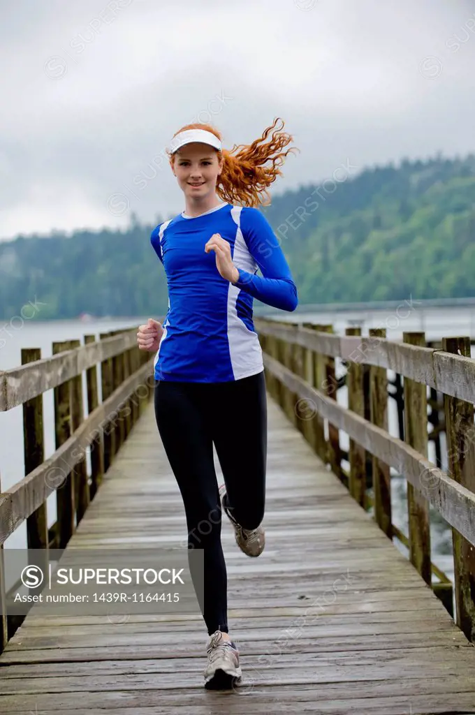 Teenage girl running on pier, Bainbridge Island, Washington, USA