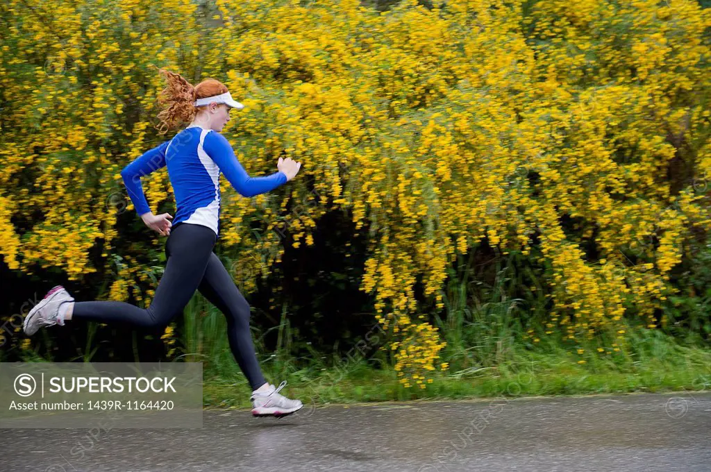 Teenage girl jogging on road, Bainbridge Island, Washington, USA