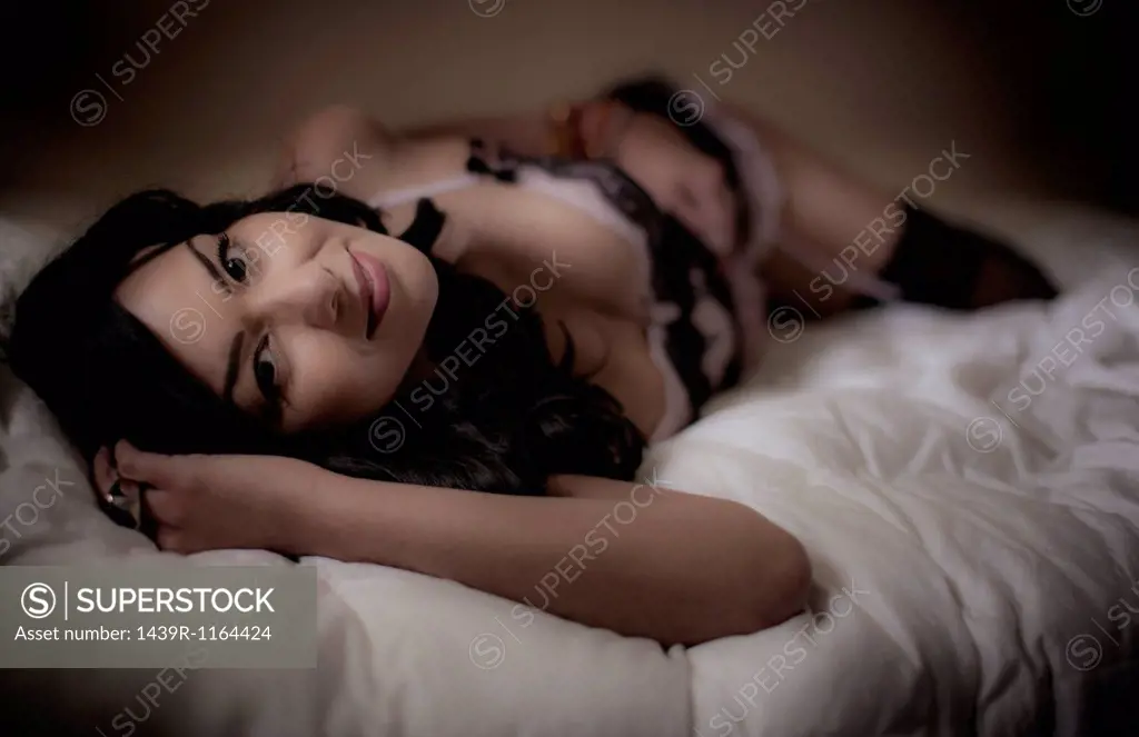 Mid adult woman lying on bed wearing lingerie