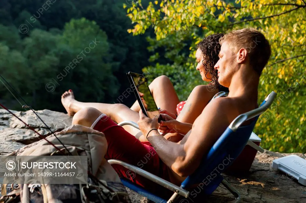 Young couple relaxing on rock ledge, Hamburg, Pennsylvania, USA