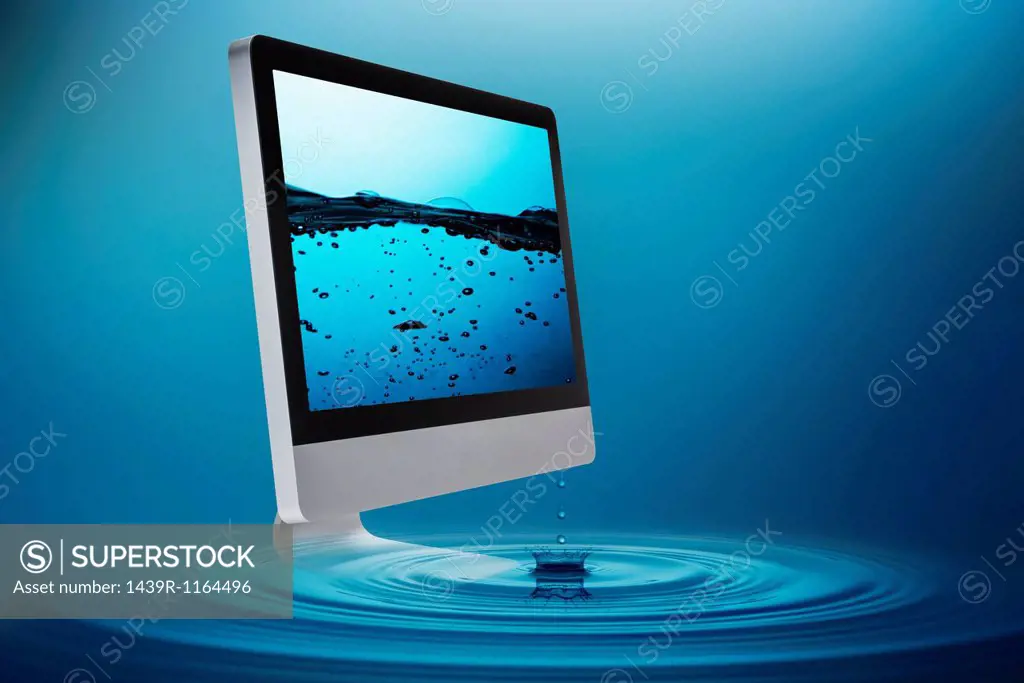 Still life with computer submerging in water