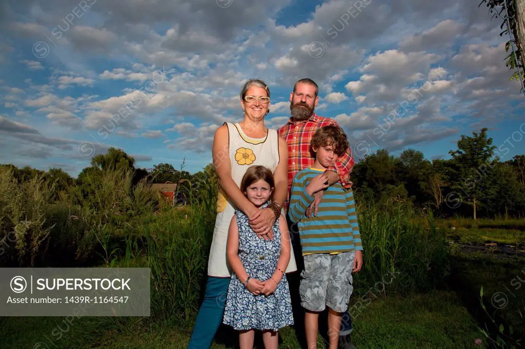 Portrait of couple with children on family herb farm