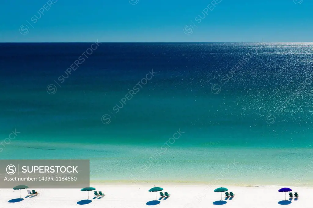 Beach umbrellas and deck chairs on beach, Destin, Florida, USA