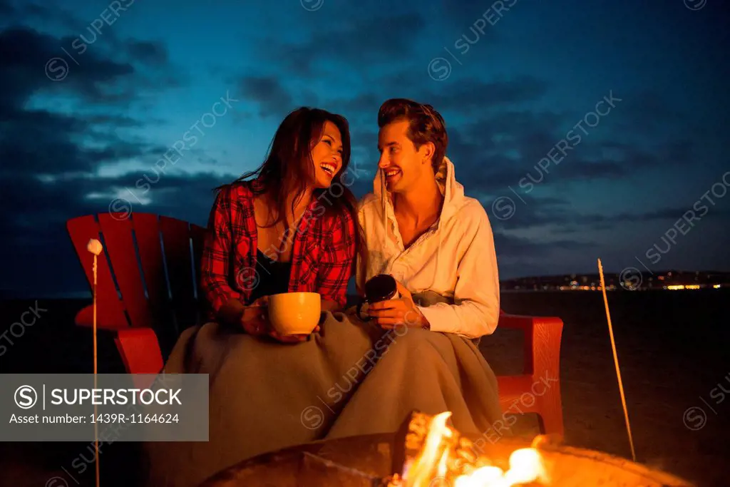 Young couple by campfire, San Diego, California, USA