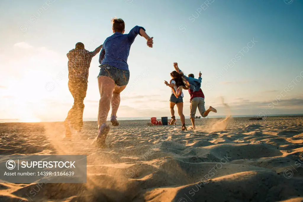 Friends running on Mission Beach, San Diego, California, USA