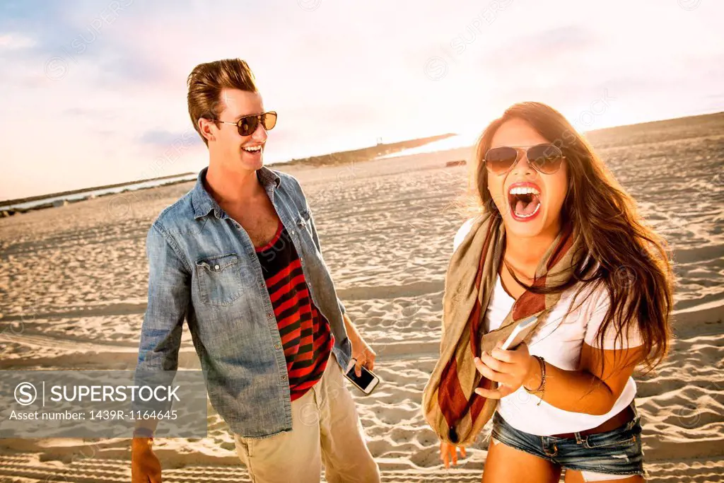 Young couple laughing on Mission Beach, San Diego, California, USA