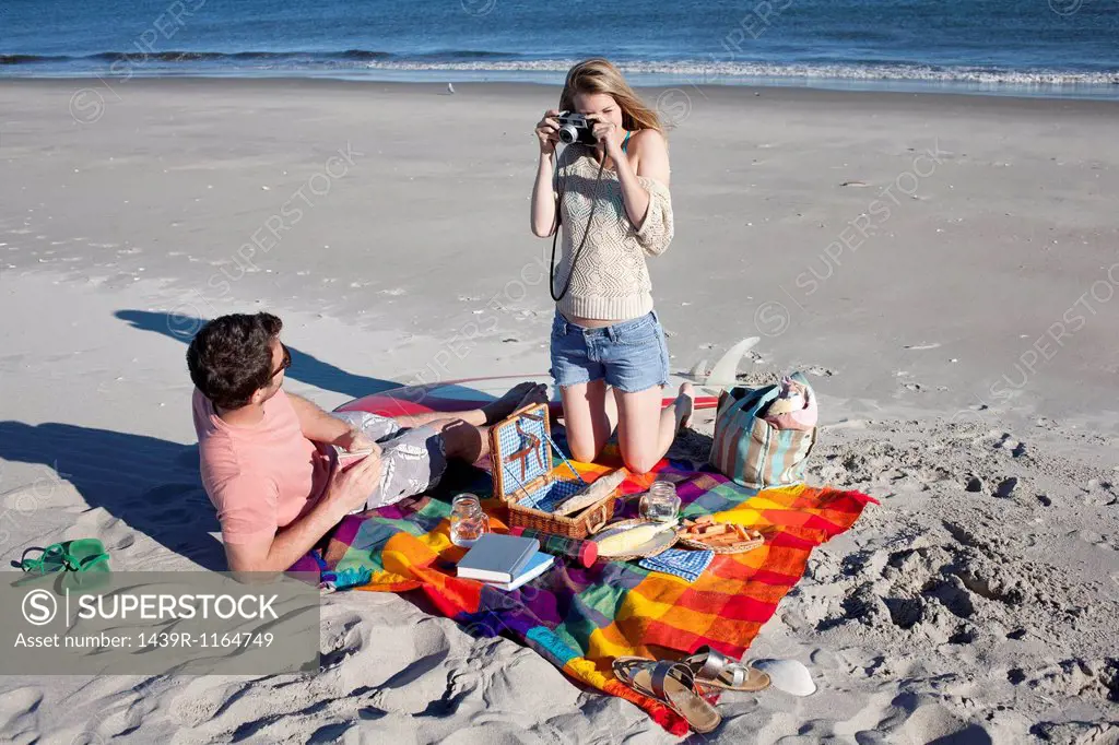 Couple picnicing and photographing, Breezy Point, Queens, New York, USA