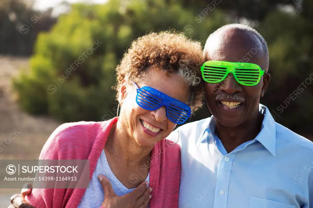 Senior couple wearing blue and green plastic glasses