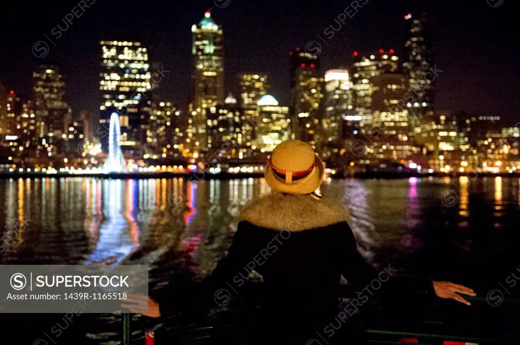 Woman and Seattle skyline at night, Washington, USA