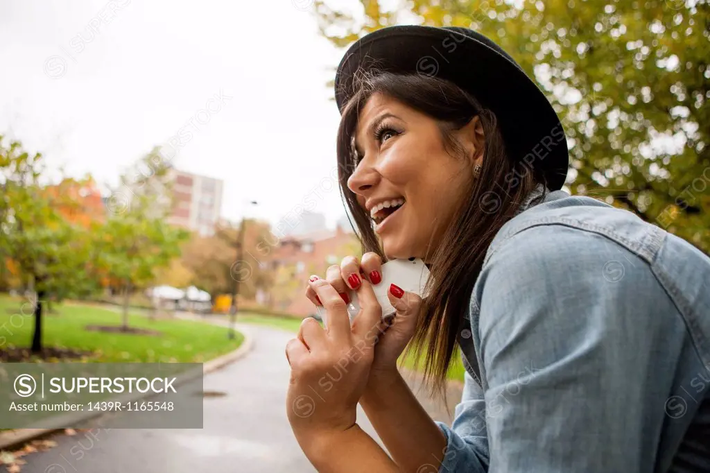 Woman holding cellular phone to chin
