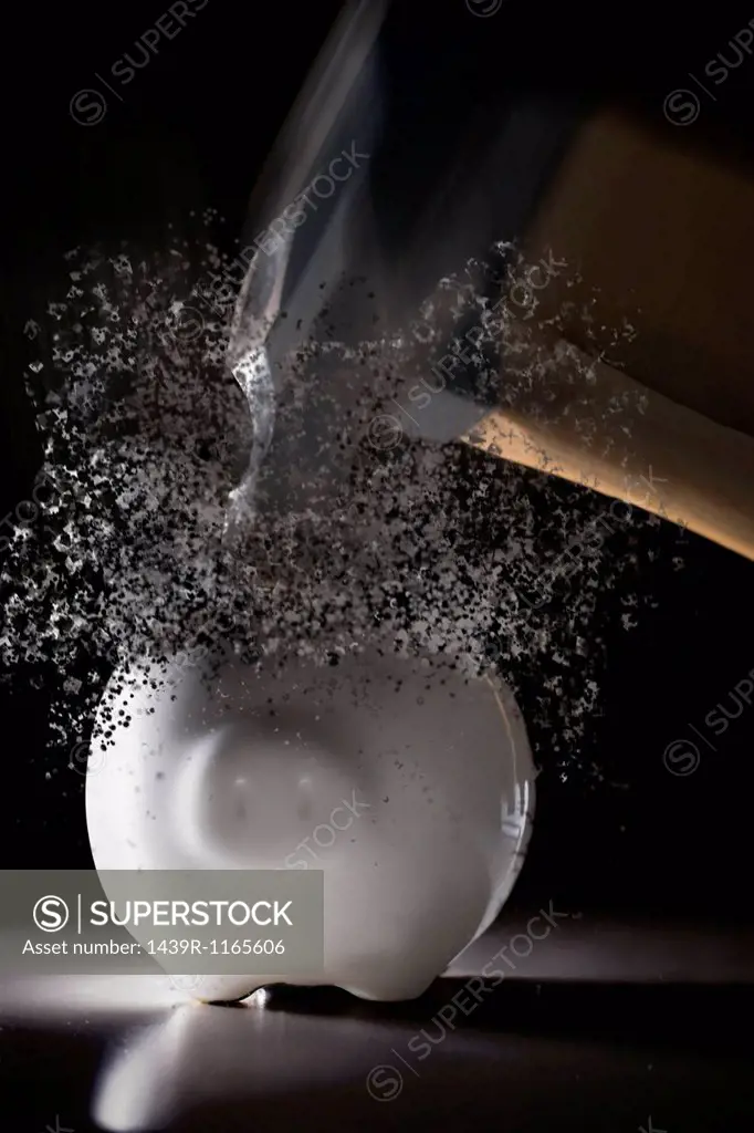 Close up hammer hitting piggy bank with blurred motion