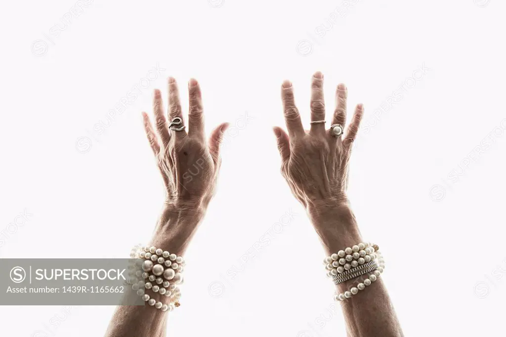 Studio shot of mature woman´s reaching hands