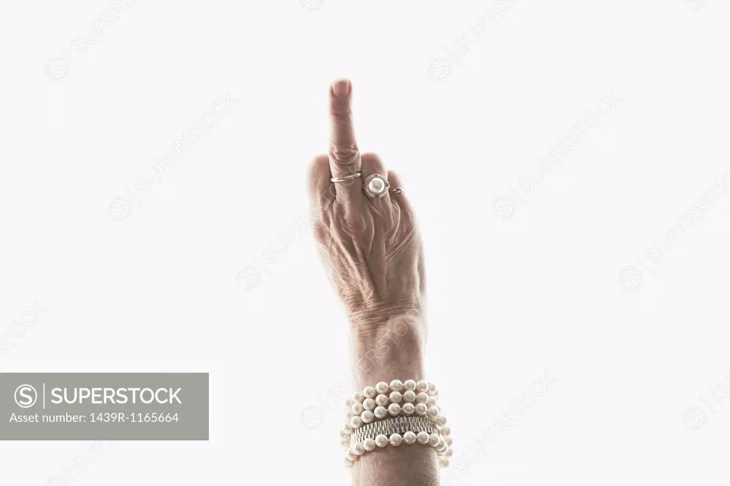 Studio shot of mature woman´s hand making obscene gesture