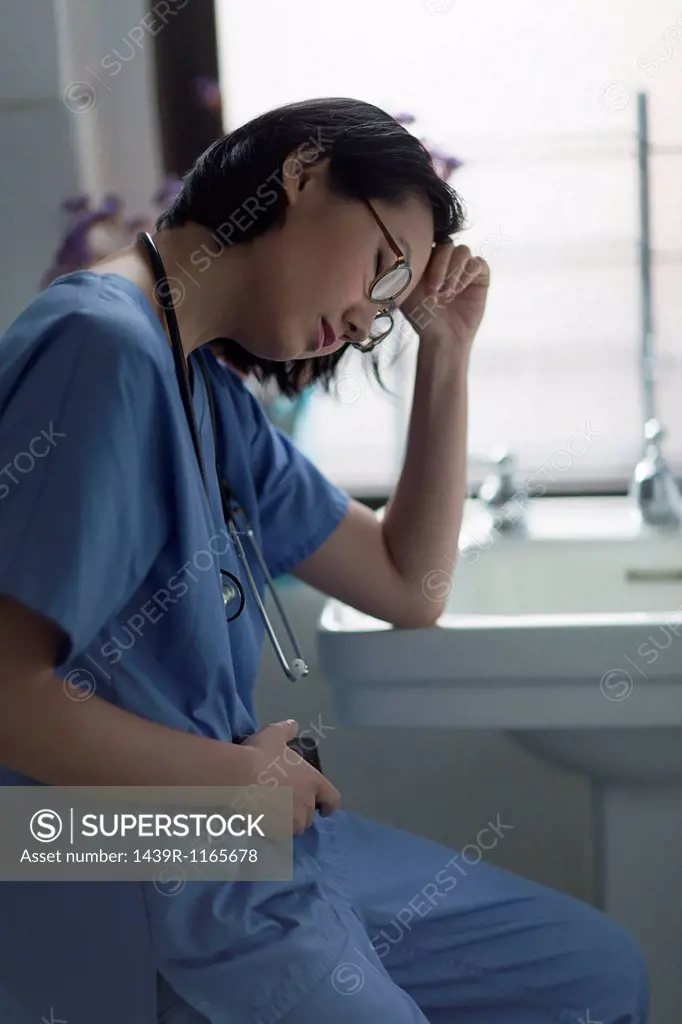 Portrait of a stressed young female doctor in office