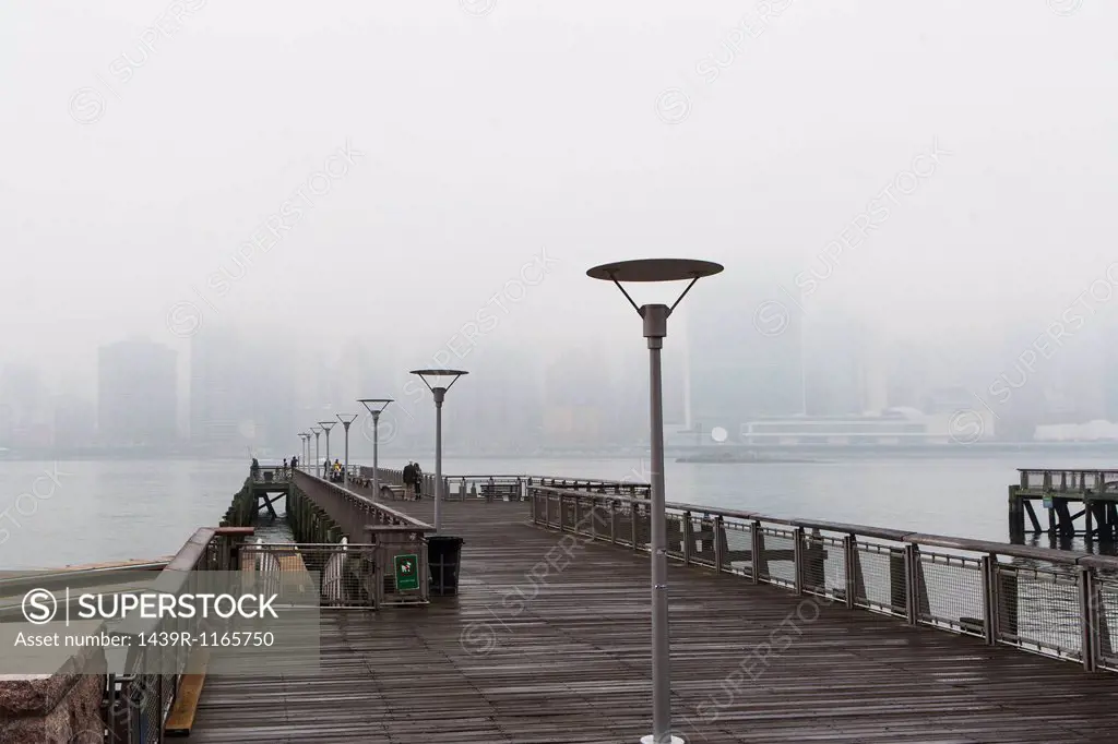 East river pier and skyline in mist, New York City, USA