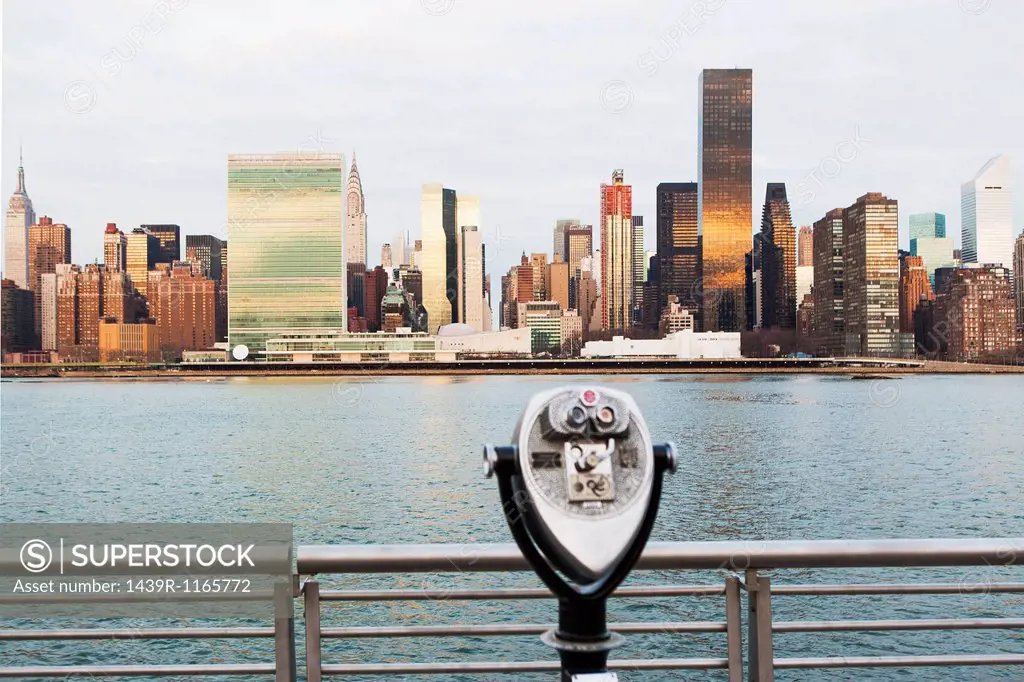 View of tourist binoculars toward East River and manhattan skyline, New York, USA