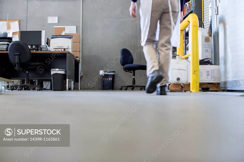 Factory worker walking along floor, low section