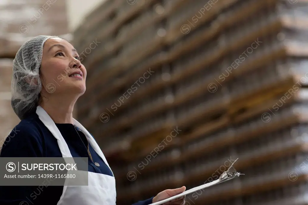 Factory worker with clipboard in warehouse