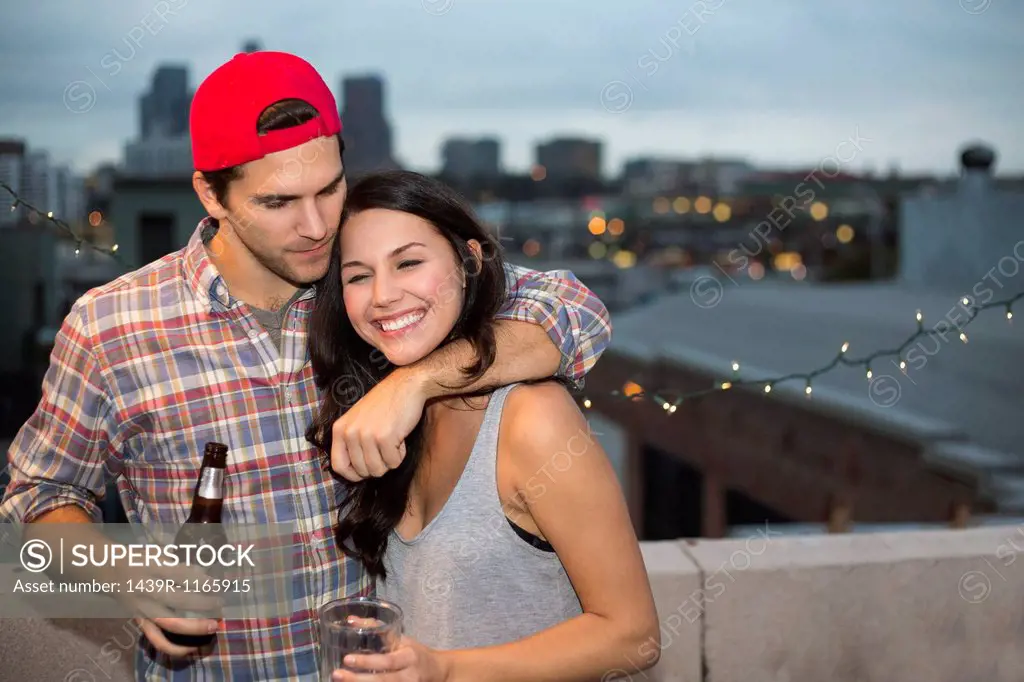 Young couple having fun at rooftop barbecue
