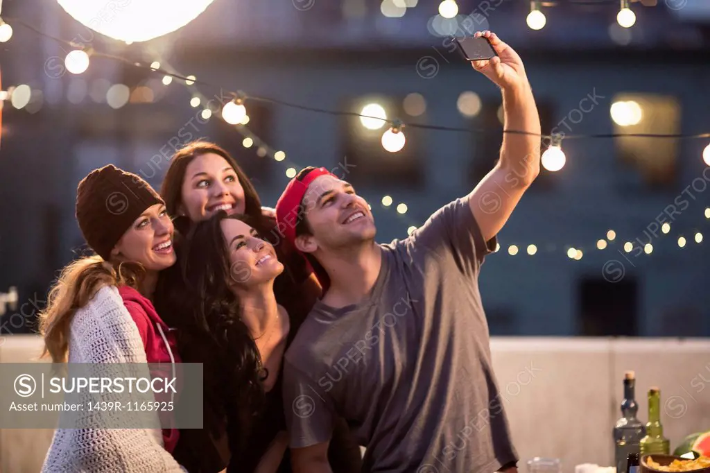 Young adult friends taking self portrait at party